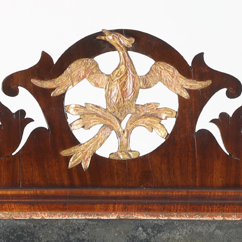 A rectangular Georgian mahogany wall mirror featuring a scroll-cut fretwork frame topped with a gilded ho-ho bird cresting. View IV
