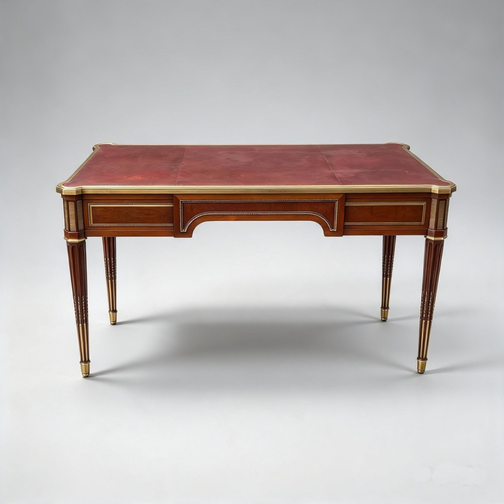 A French Napoleon III style mahogany bureau plat featuring a red leather inset top, gilt bronze mounts, three frieze drawers, and tapered fluted legs. View III