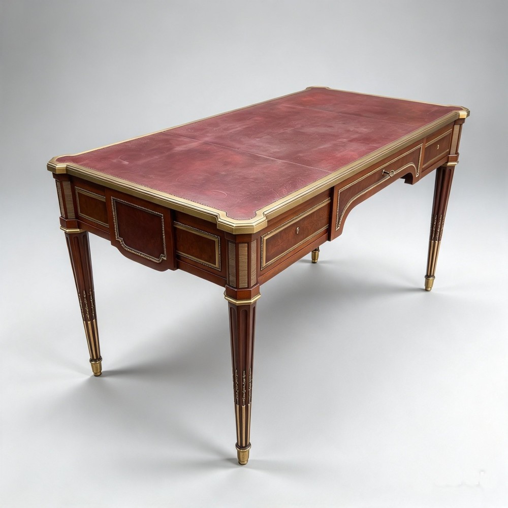 A French Napoleon III style mahogany bureau plat featuring a red leather inset top, gilt bronze mounts, three frieze drawers, and tapered fluted legs. View XI