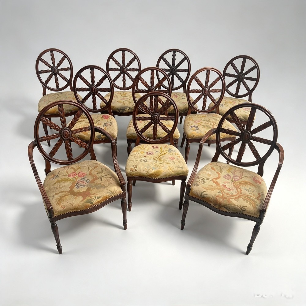 A set of ten mahogany wheelback dining chairs with carved circular backs and floral tapestry upholstered seats.