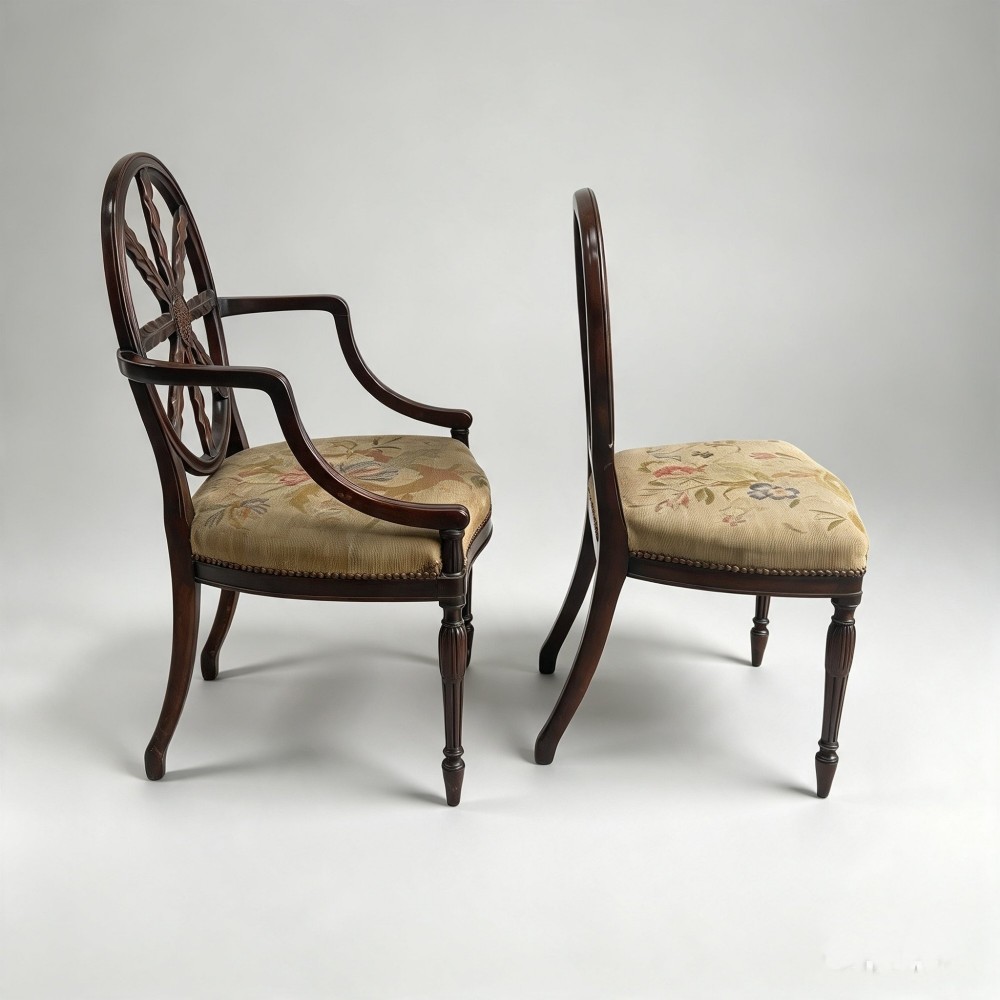 A set of ten mahogany wheelback dining chairs with carved circular backs and floral tapestry upholstered seats. View II