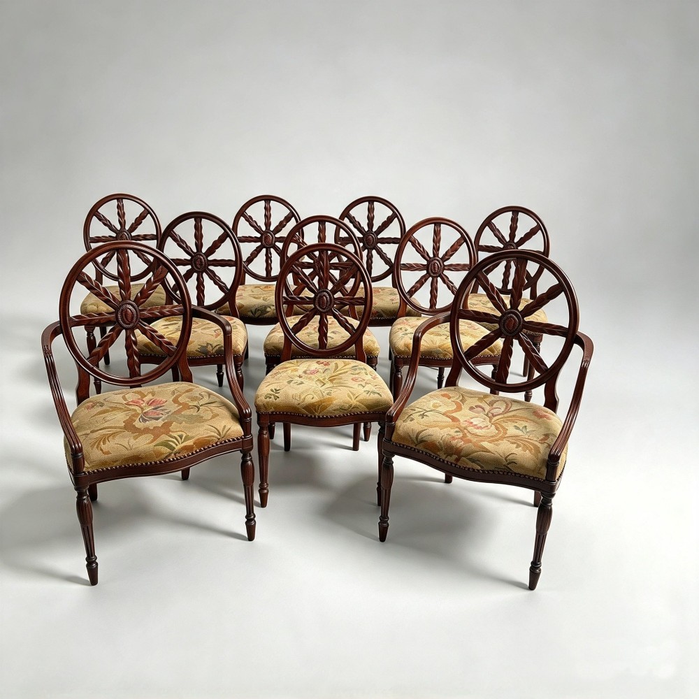 A set of ten mahogany wheelback dining chairs with carved circular backs and floral tapestry upholstered seats. View V