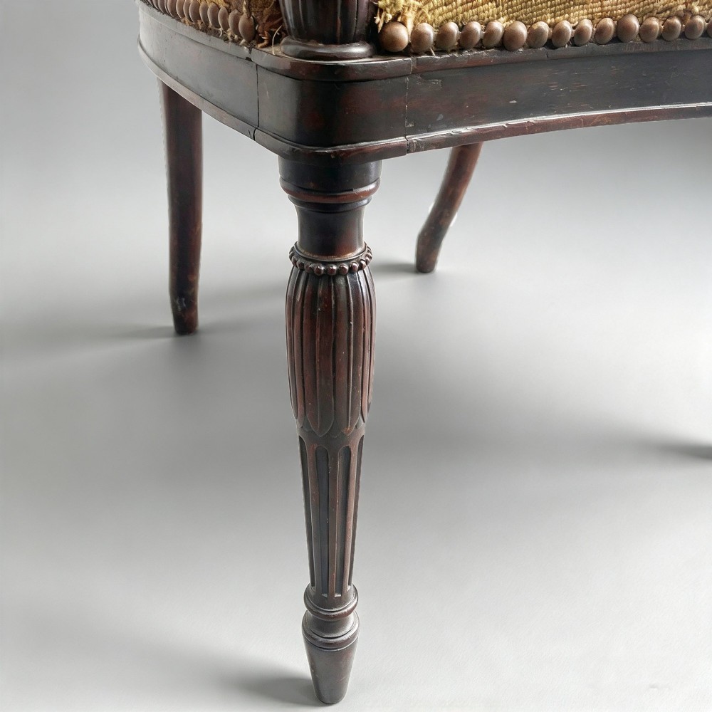 A set of ten mahogany wheelback dining chairs with carved circular backs and floral tapestry upholstered seats. View VI