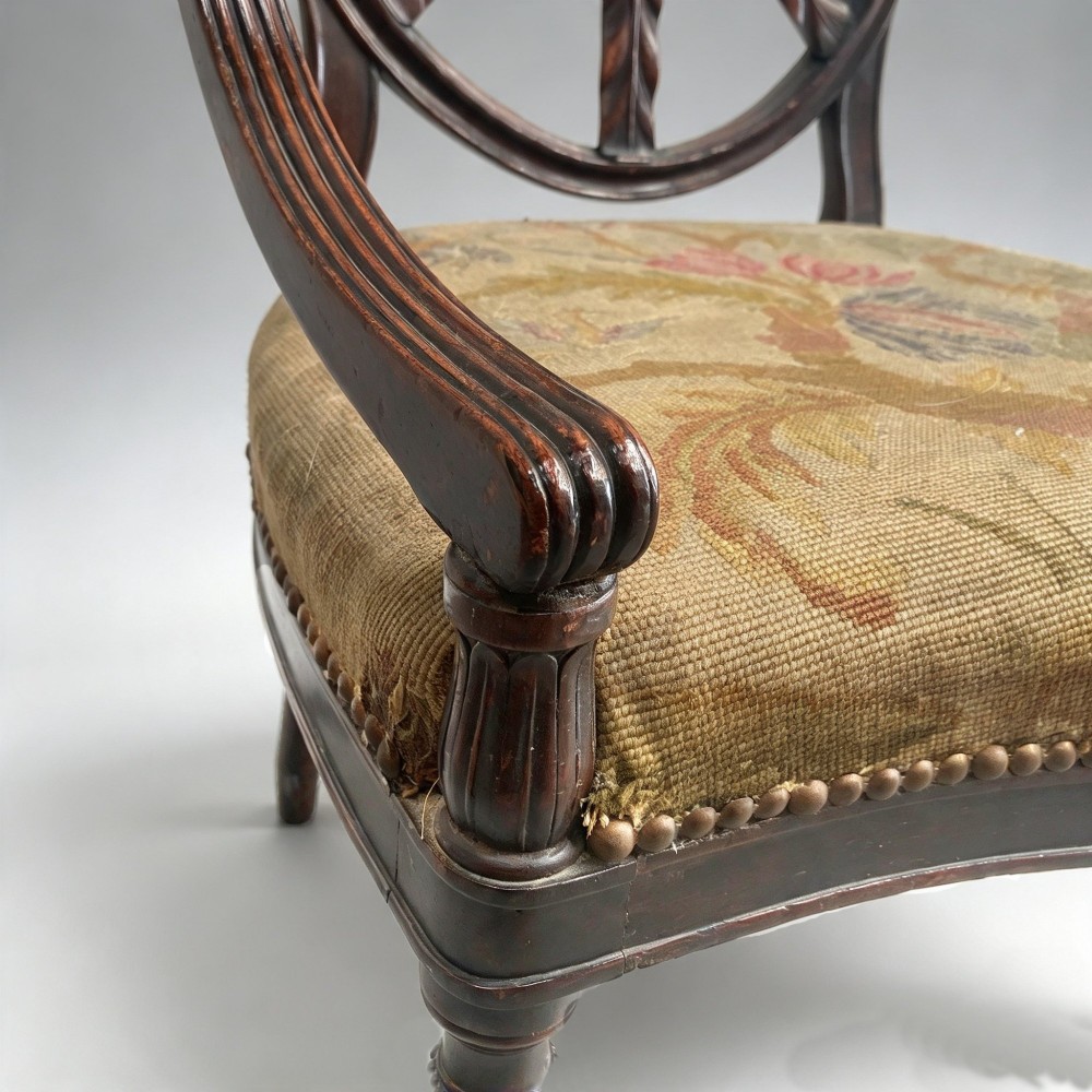 A set of ten mahogany wheelback dining chairs with carved circular backs and floral tapestry upholstered seats. View VII