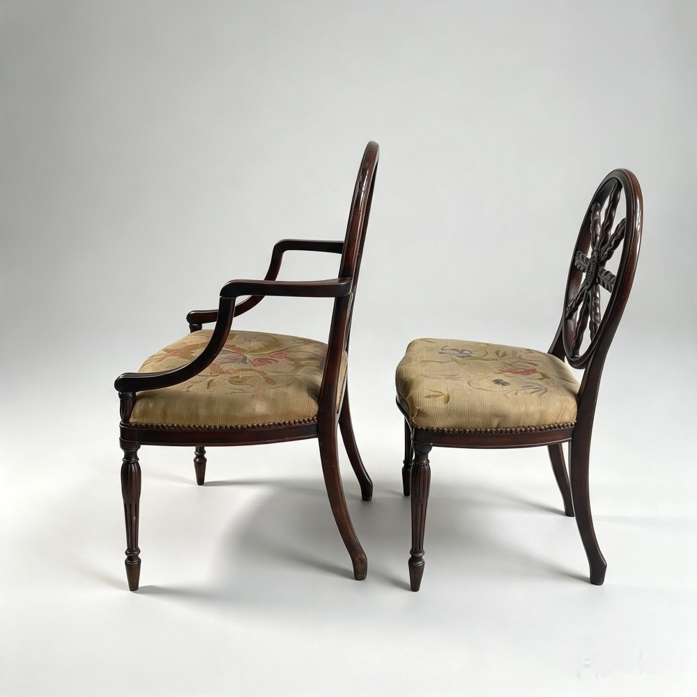 A set of ten mahogany wheelback dining chairs with carved circular backs and floral tapestry upholstered seats. View VIII