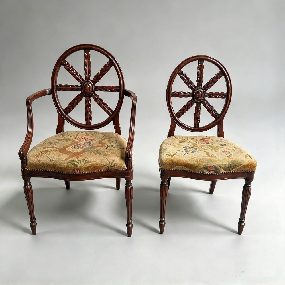 A set of ten mahogany wheelback dining chairs with carved circular backs and floral tapestry upholstered seats. View IX