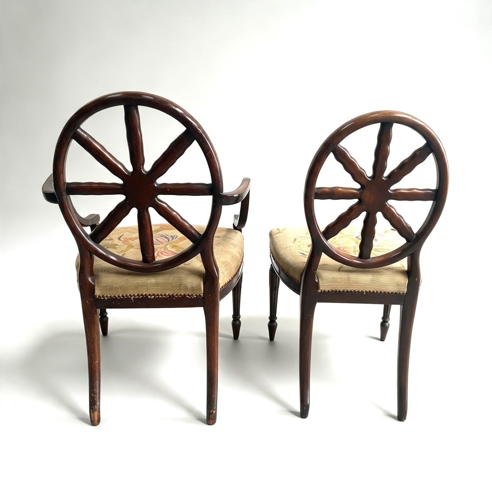 A set of ten mahogany wheelback dining chairs with carved circular backs and floral tapestry upholstered seats. View XIII