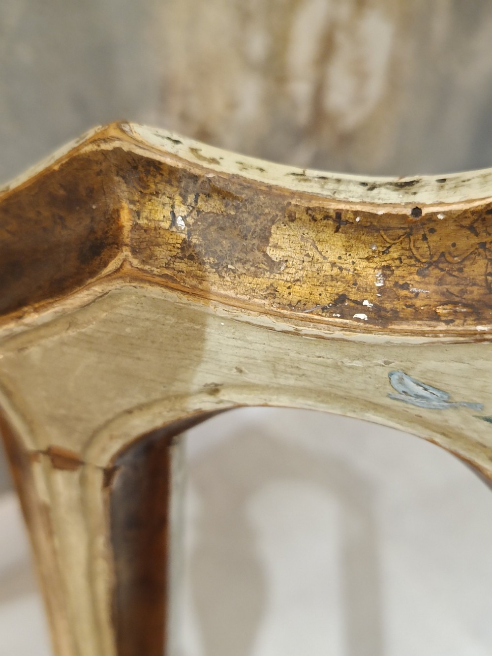 A pair of 18th-century North Italian side chairs featuring distressed cream painted frames with carved crests, cabriole legs, and red velvet seats. View V