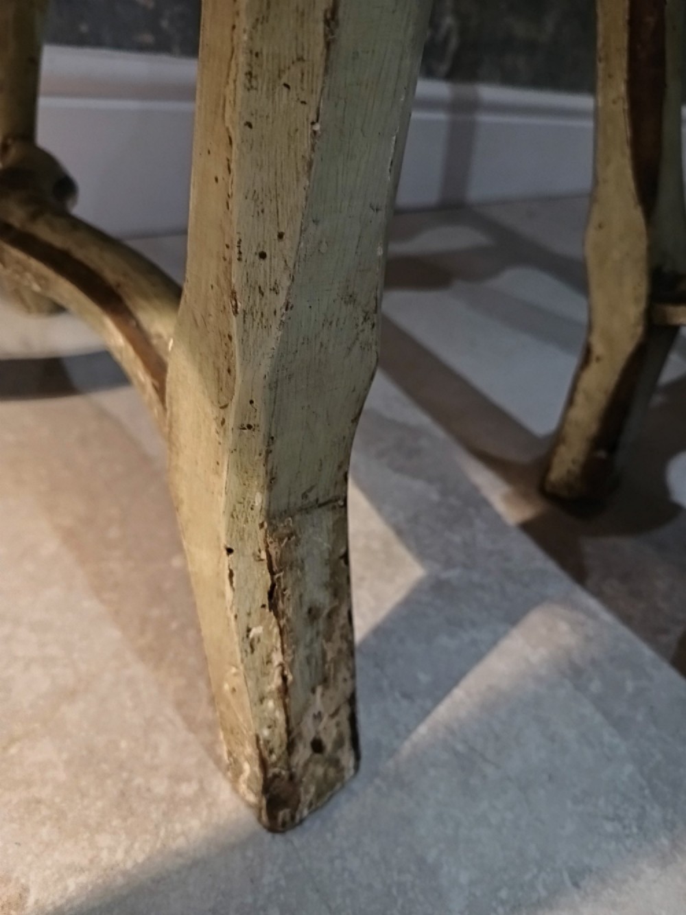 A pair of 18th-century North Italian side chairs featuring distressed cream painted frames with carved crests, cabriole legs, and red velvet seats. View XIII