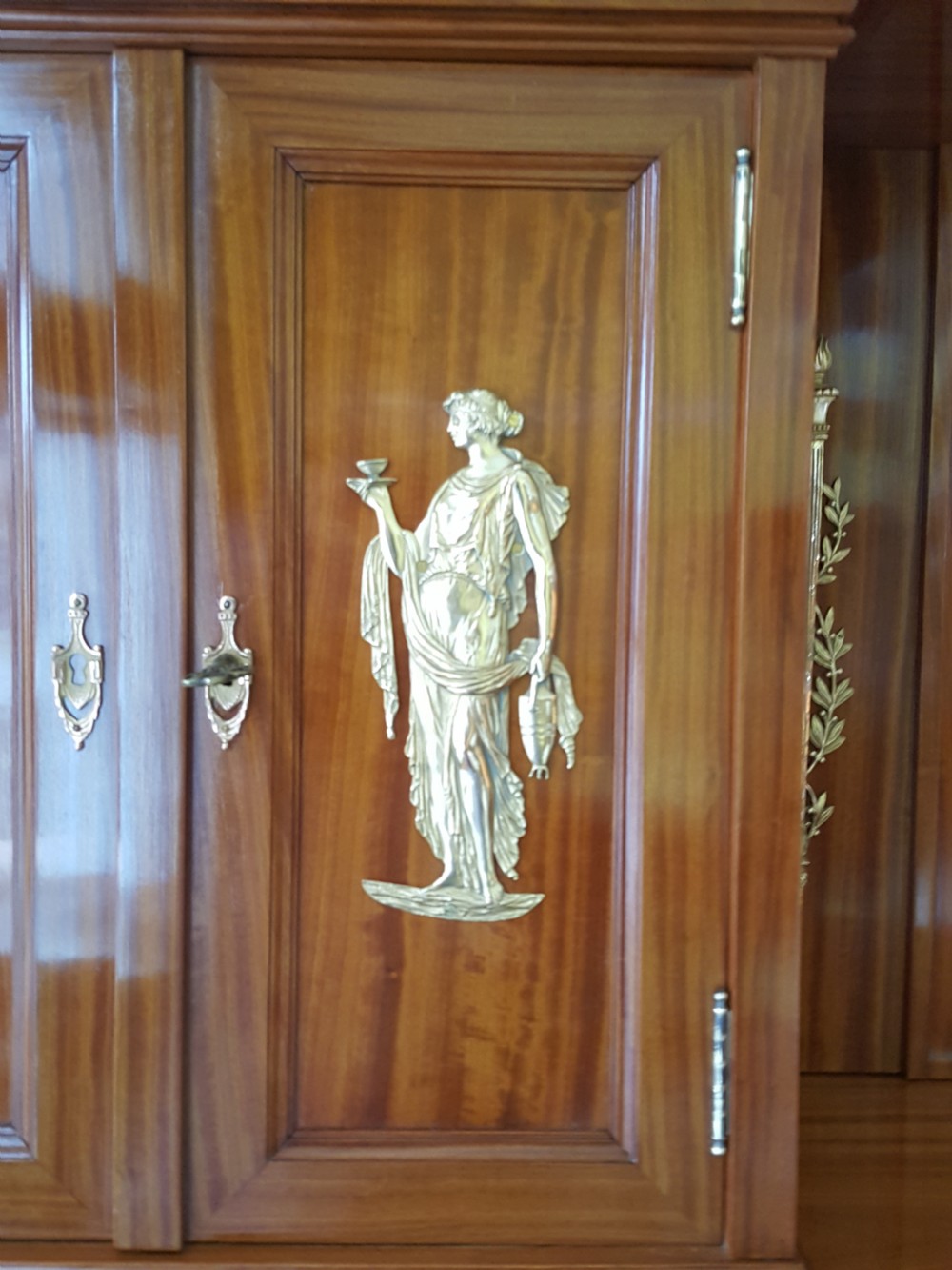 A tall late 19th-century Swiss satinwood salon cabinet featuring a pediment top, gilded metal mounts, glazed display compartments, central mirror, and inlaid door panels. View III
