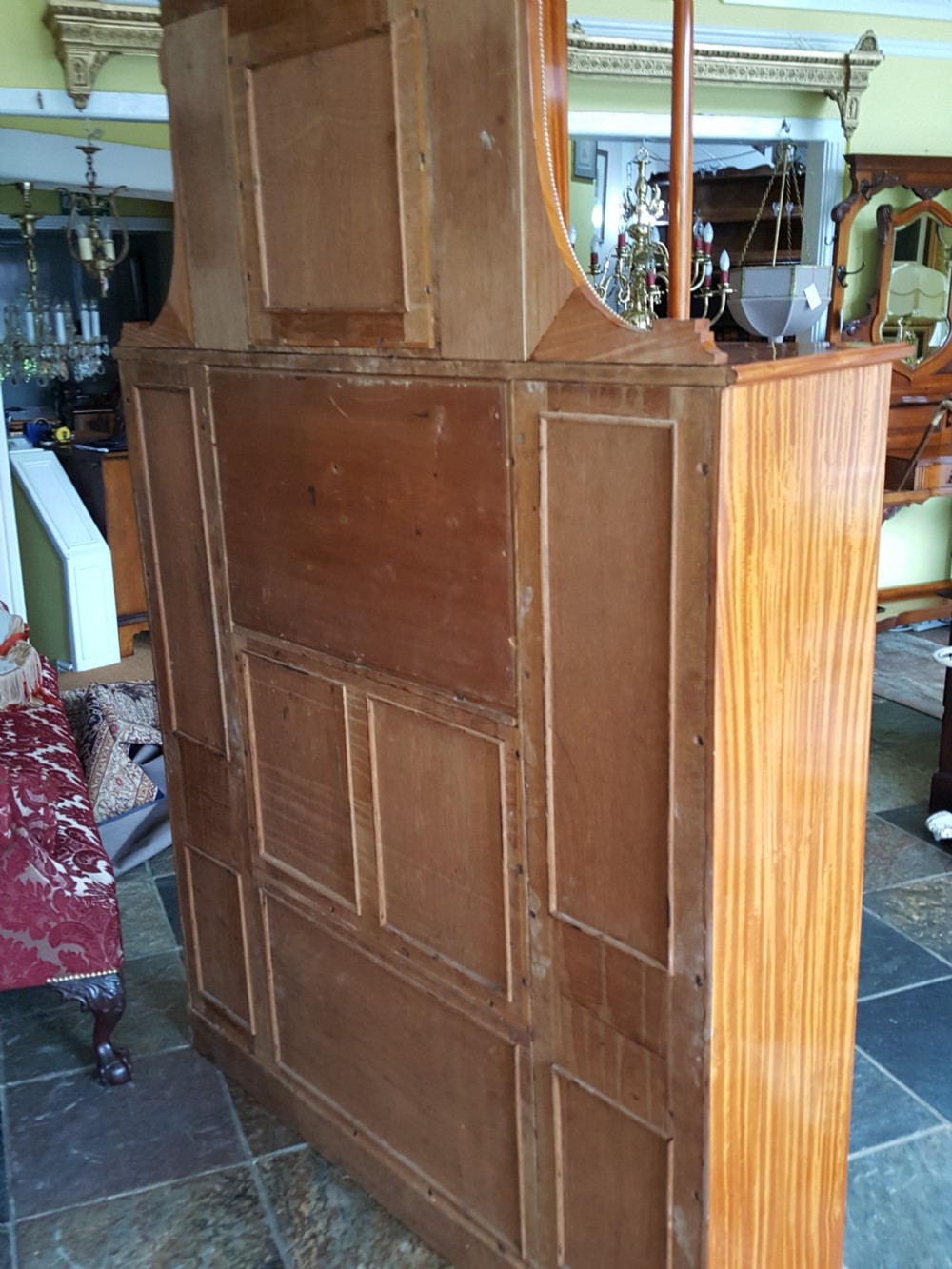 A tall late 19th-century Swiss satinwood salon cabinet featuring a pediment top, gilded metal mounts, glazed display compartments, central mirror, and inlaid door panels. View XIX