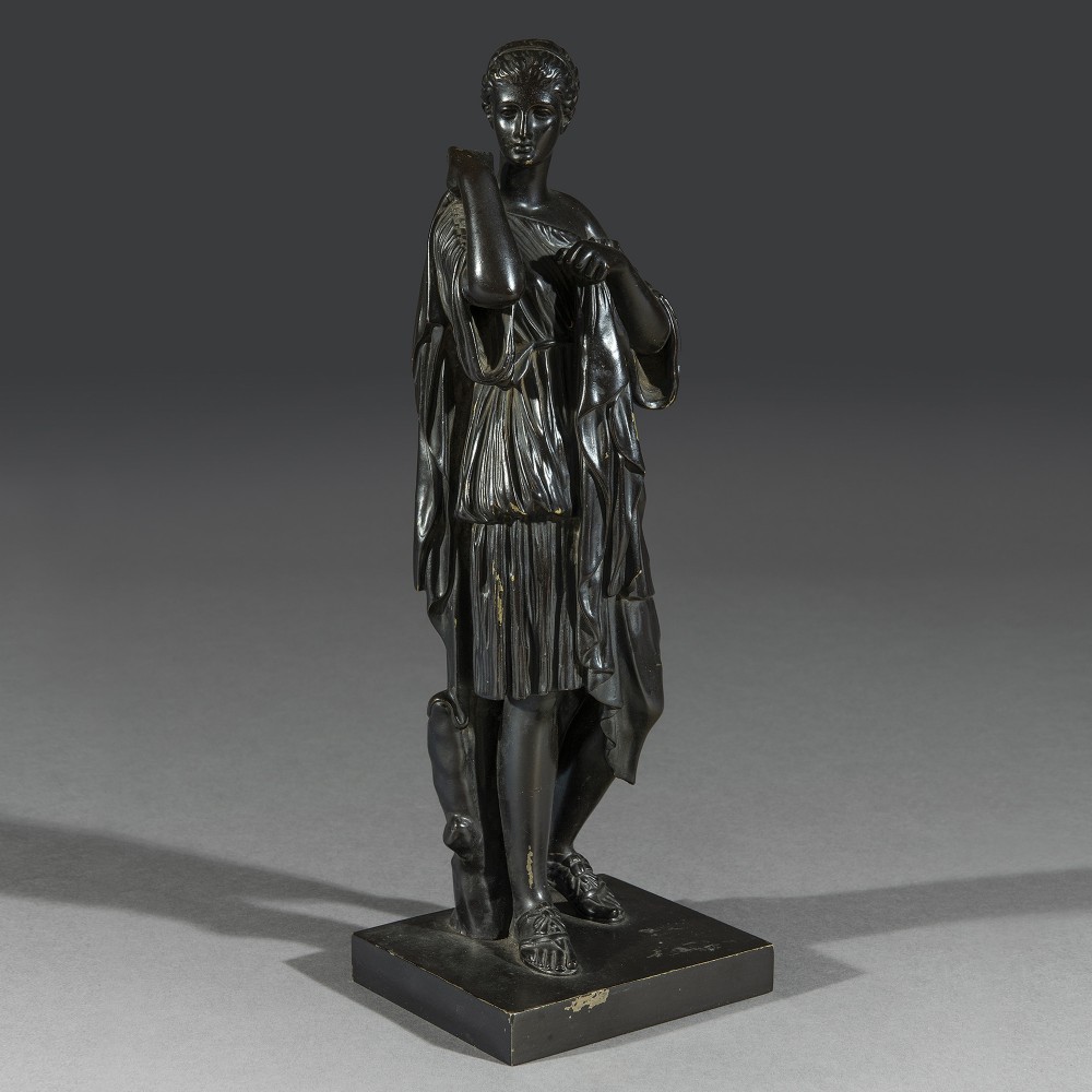 A dark patinated cast bronze figure depicting the goddess Diana of Gabii draped in a classical tunic, standing on a square bronze base.
