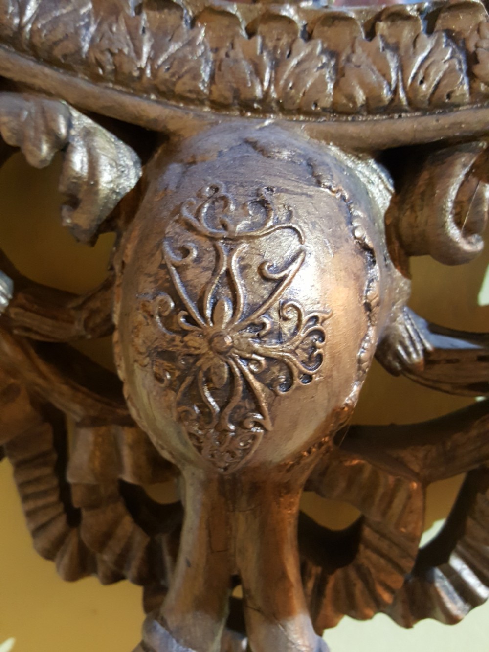 An ornate oval giltwood girandole mirror featuring carved acanthus cresting, ribbon detailing, and two candle sconces at the base. View III