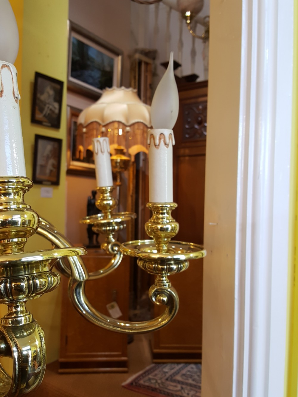 An early twentieth-century brass chandelier featuring eight S-scroll arms surrounding a turned central baluster stem with candle sleeves. View IV