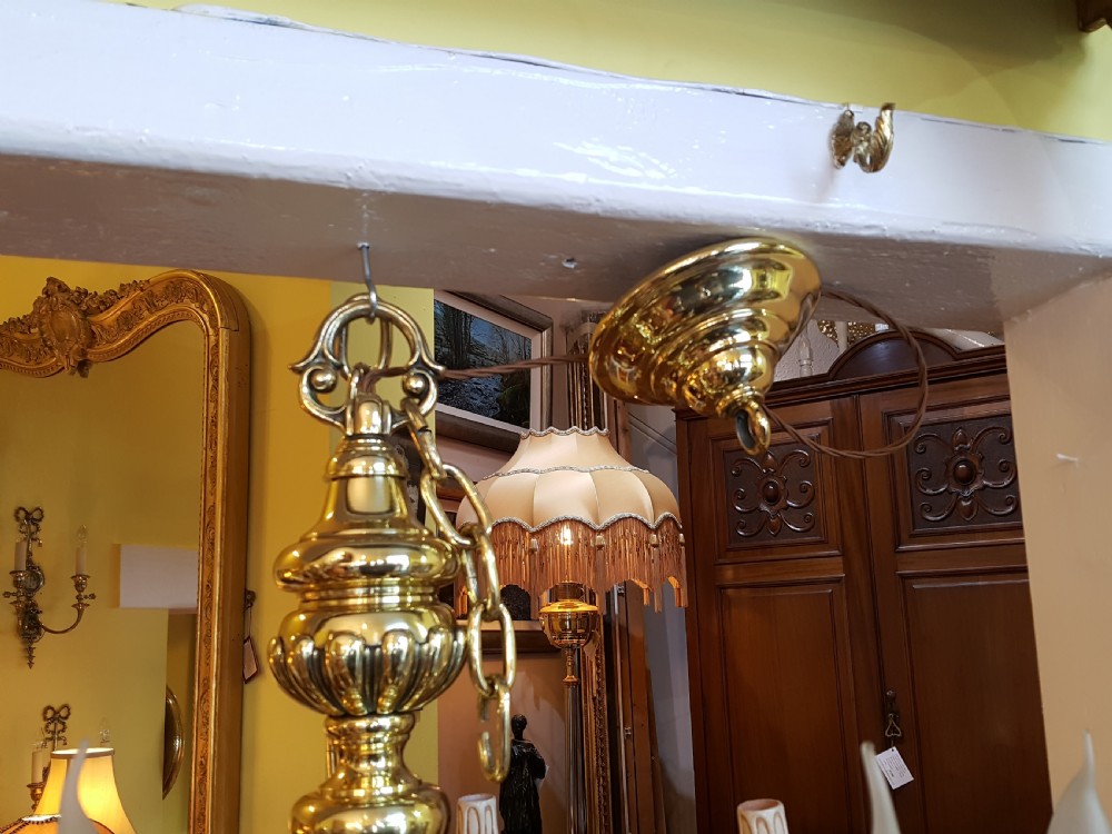 An early twentieth-century brass chandelier featuring eight S-scroll arms surrounding a turned central baluster stem with candle sleeves. View VII
