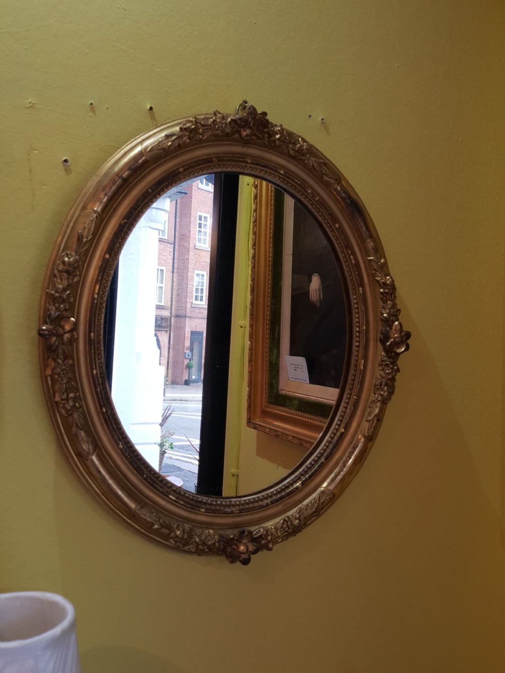 A pair of matching oval wall mirrors housed in carved giltwood frames decorated with floral motifs and beaded borders. View VII