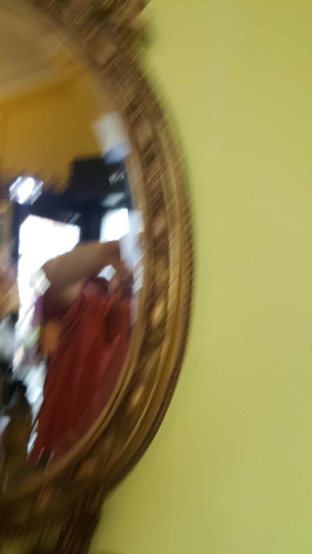 A 19th-century oval giltwood wall mirror featuring an ornate shell cresting, candle sconces at the base, and an inset miniature portrait. View V