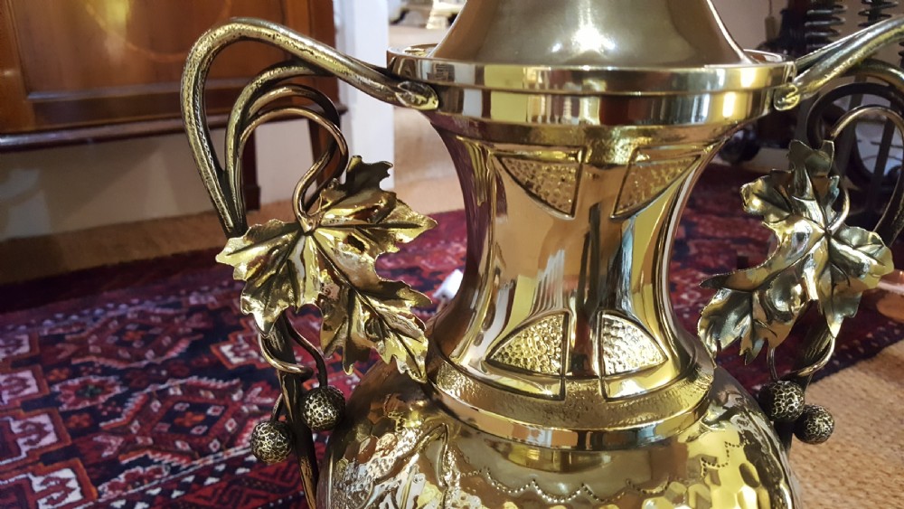 An Art Nouveau brass table lamp shaped like an urn with foliate handles and an intricate patterned fabric shade with decorative fringe. View IV