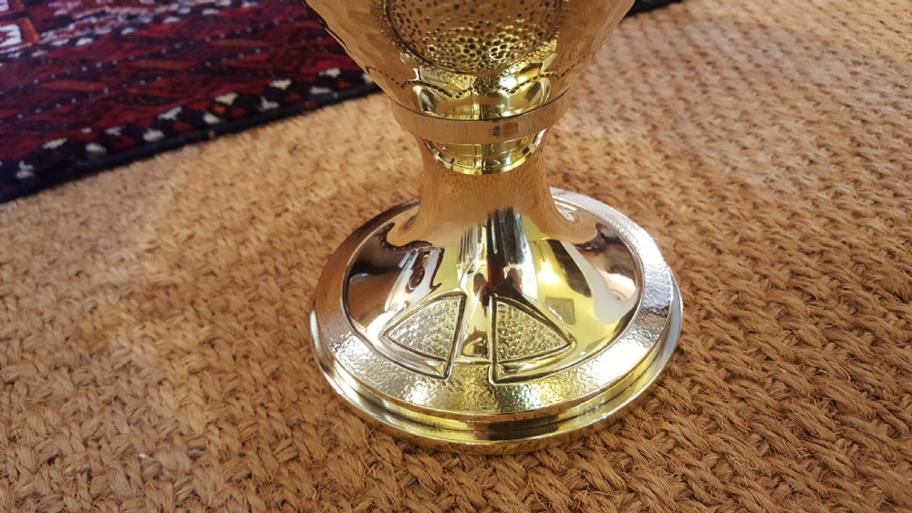 An Art Nouveau brass table lamp shaped like an urn with foliate handles and an intricate patterned fabric shade with decorative fringe. View VI