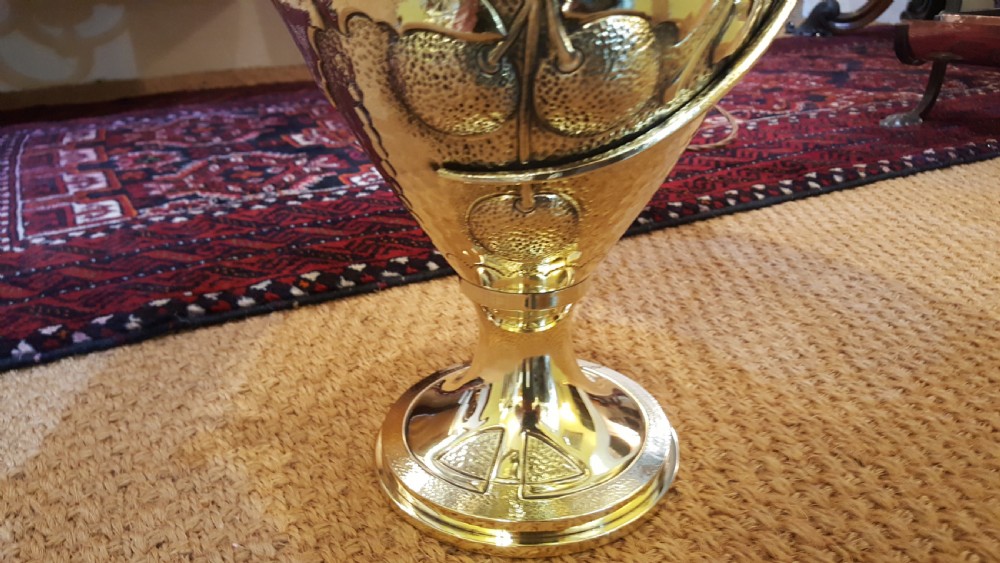 An Art Nouveau brass table lamp shaped like an urn with foliate handles and an intricate patterned fabric shade with decorative fringe. View VII