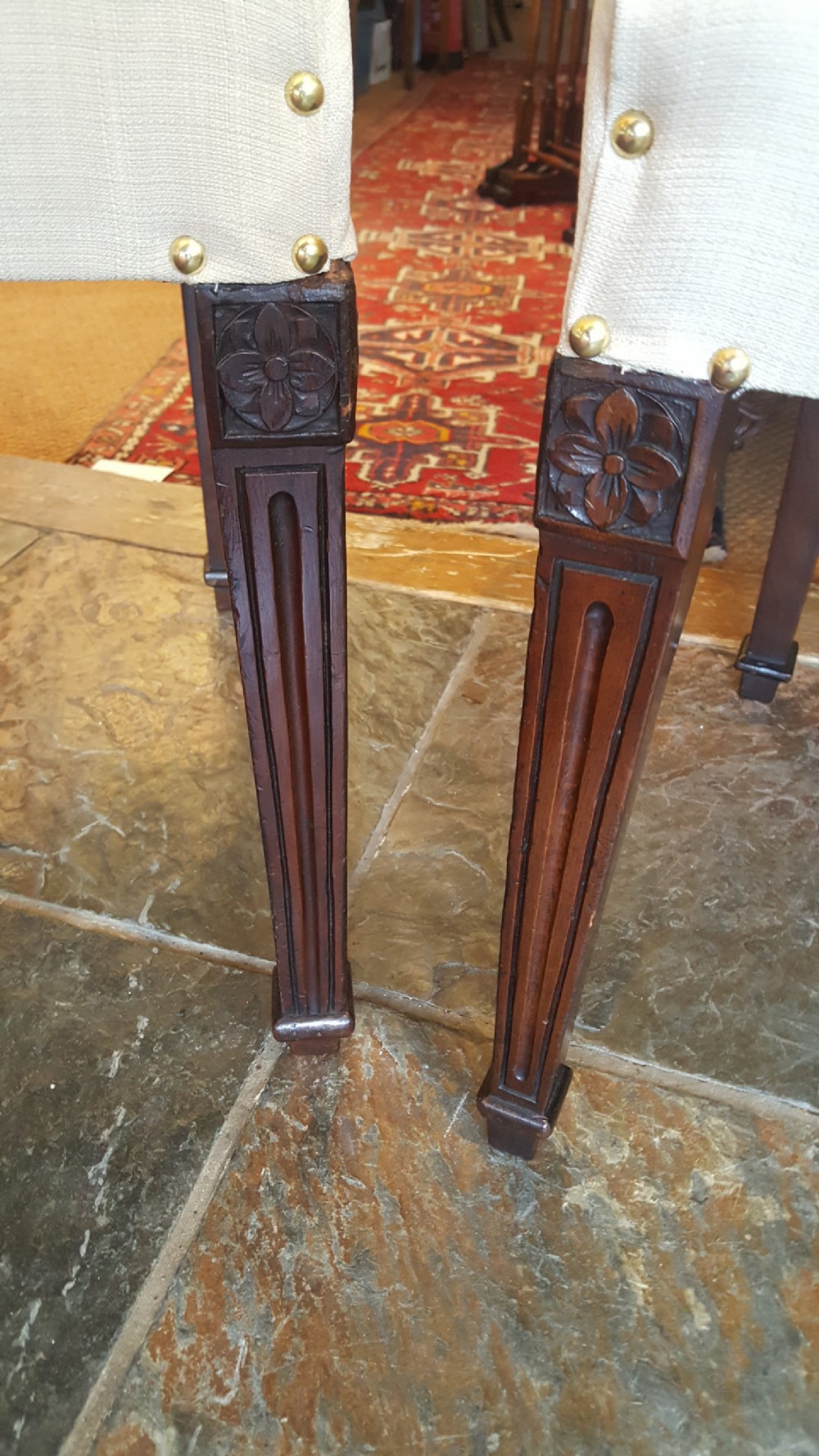 A set of four Regency mahogany side chairs featuring carved lyre back splats inside circular frame apertures, with off-white upholstered seats and fluted front legs. View V