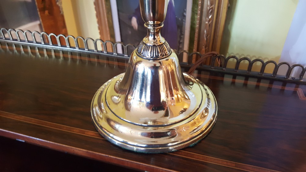 An early twentieth-century polished brass table lamp featuring a contoured stem and a white scalloped fabric shade with embroidered details. View II