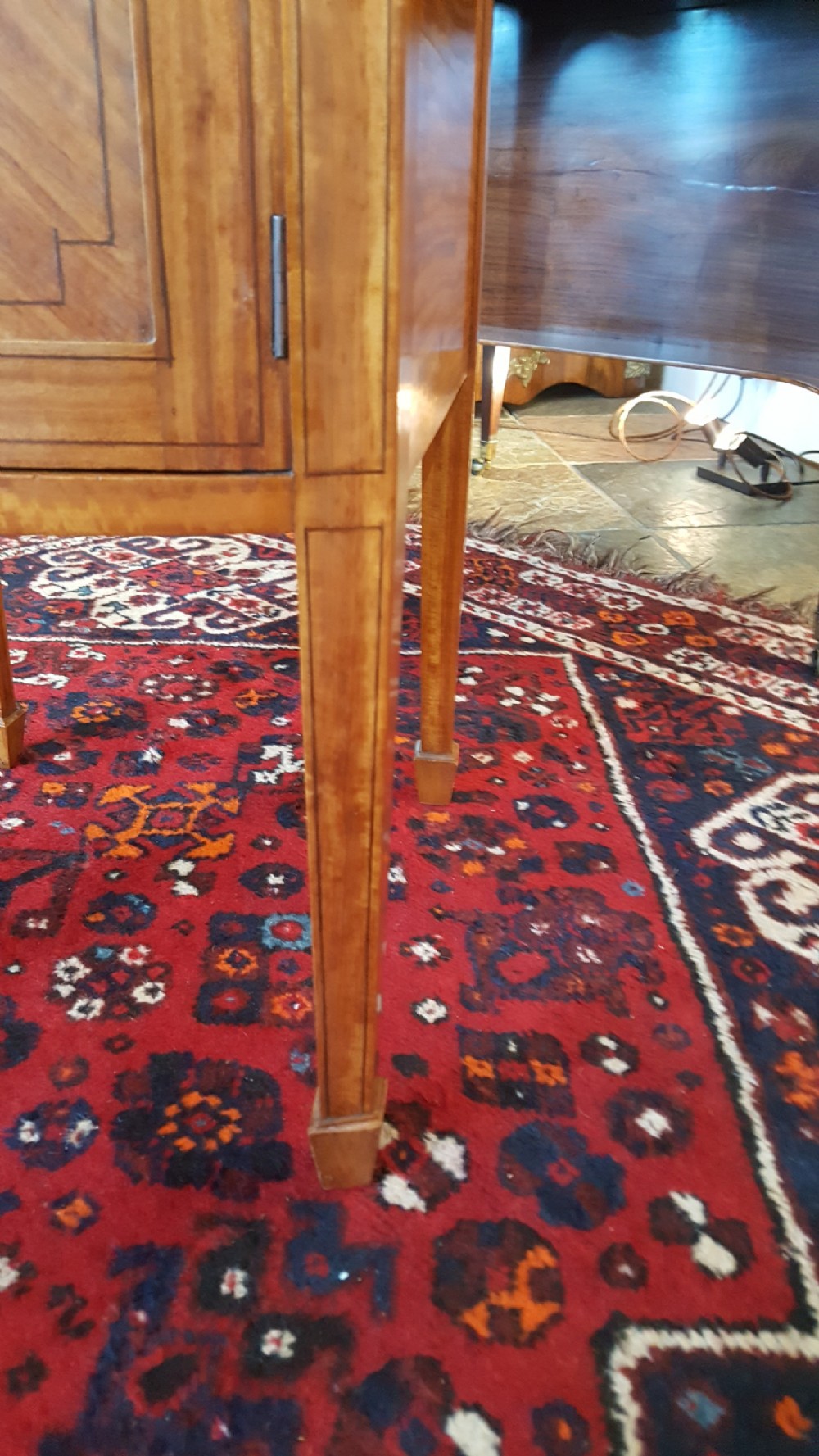 An antique Sheraton Revival satinwood bow-fronted bedside cabinet featuring a top drawer above a single cupboard door with geometric parquetry on square tapered legs. View VI