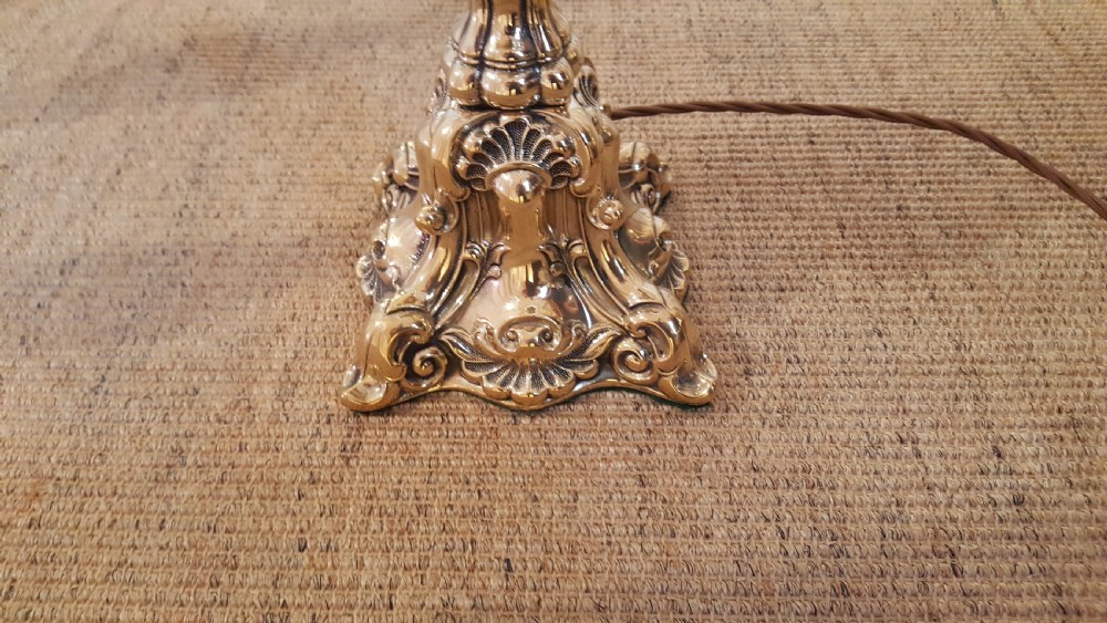 A Victorian brass oil lamp featuring a decorative cast base, fluted stem, central brass reservoir, and a white glass shade. View II