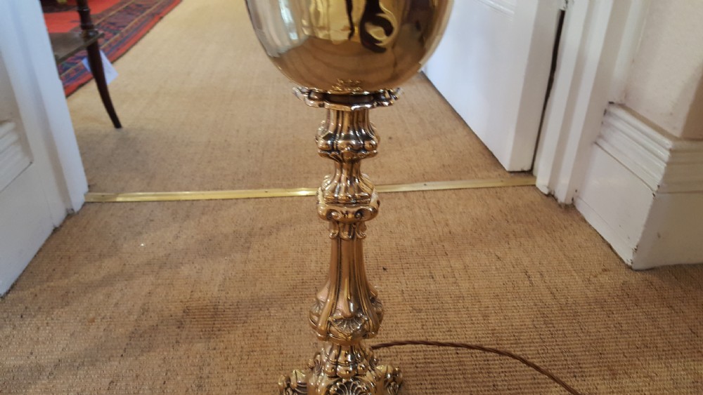 A Victorian brass oil lamp featuring a decorative cast base, fluted stem, central brass reservoir, and a white glass shade. View III