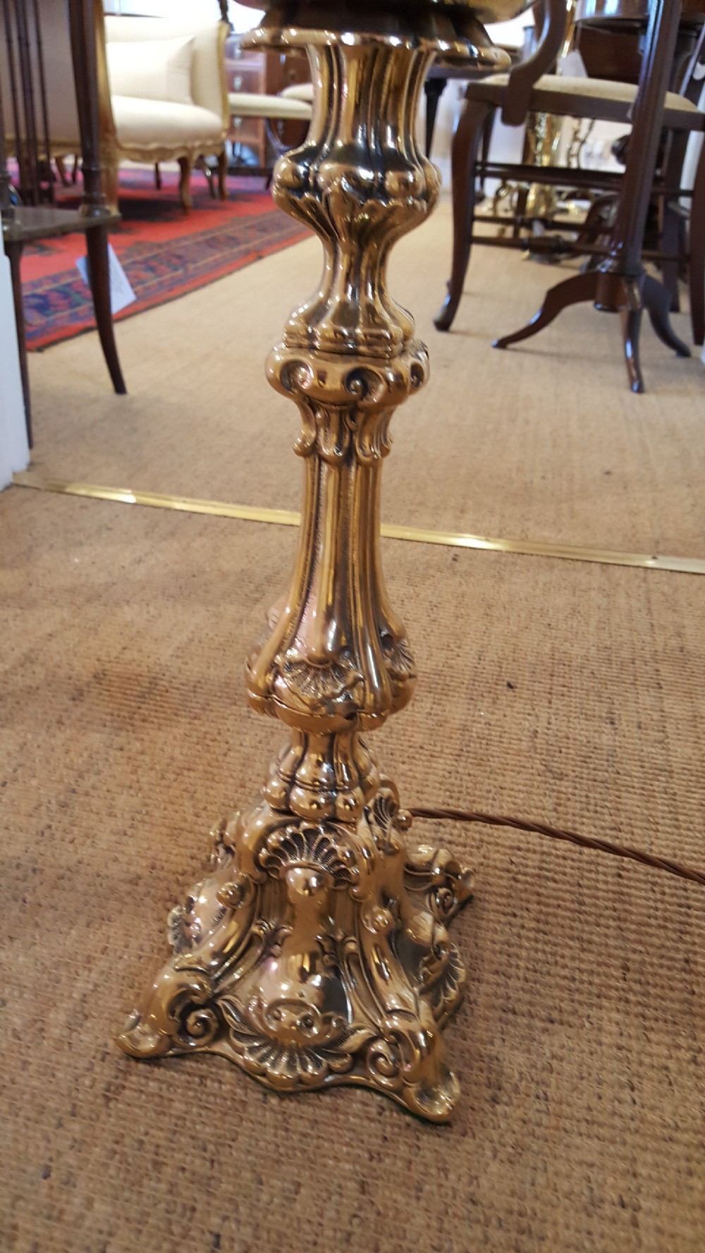 A Victorian brass oil lamp featuring a decorative cast base, fluted stem, central brass reservoir, and a white glass shade. View IV