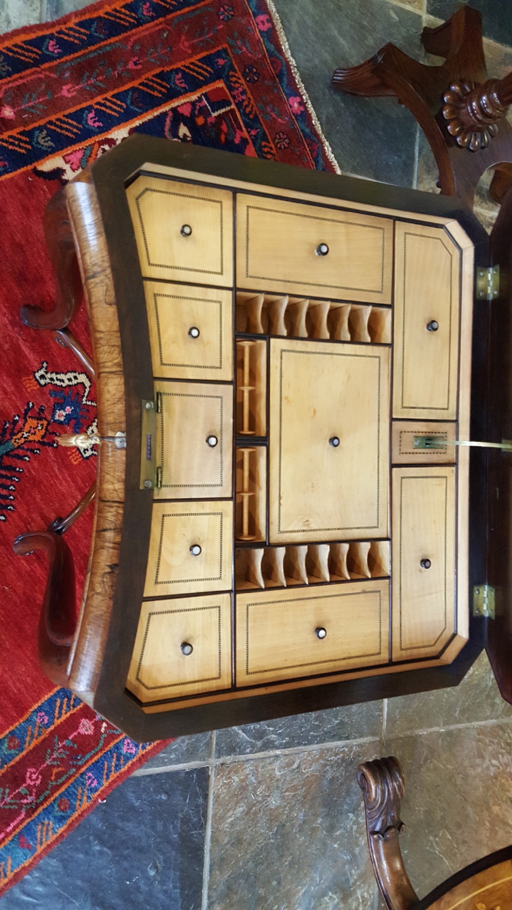 A mid-19th-century dark rosewood sewing table featuring curved cabriole legs, an X-shaped stretcher, and a fabric-covered storage basket underneath. View IV