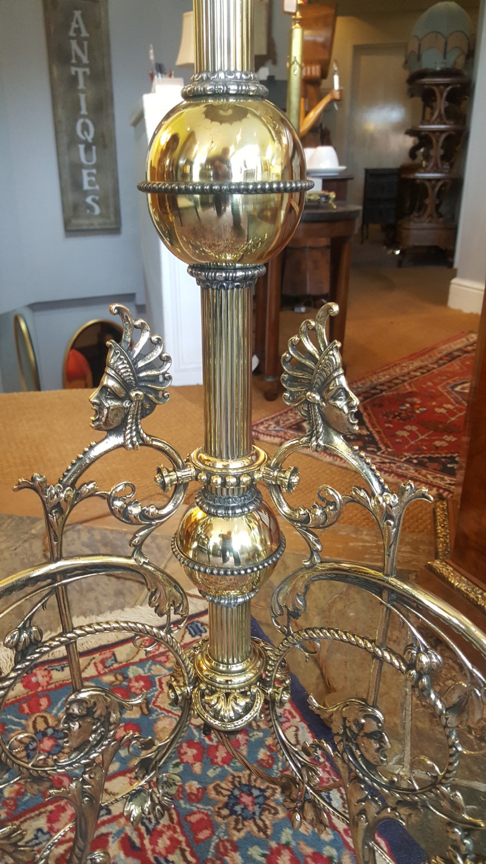 An early 20th-century brass standard lamp featuring an ornate scrollwork tripod base and a botanical patterned domed shade with cream textile fringing. View VII