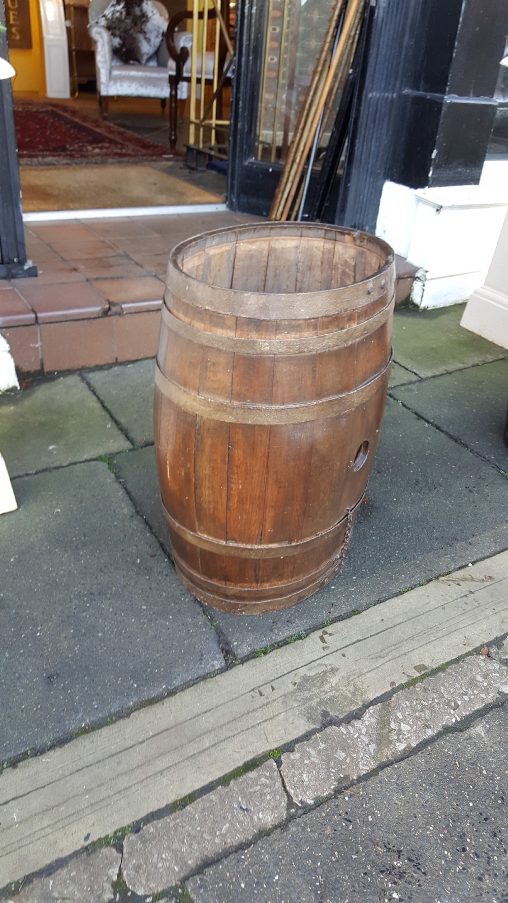 An early twentieth-century coopered oak barrel bound with dark iron hoops and featuring a central bung hole. View III