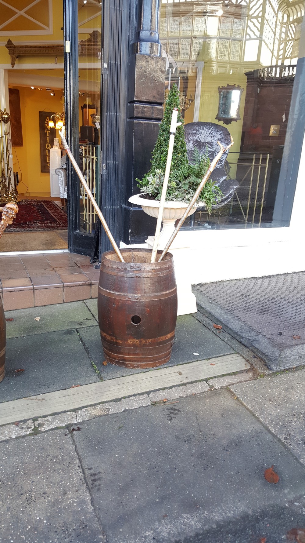 An early twentieth-century coopered oak barrel bound with dark iron hoops and featuring a central bung hole. View V
