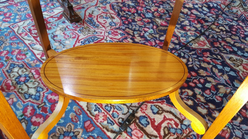 An Edwardian oval satinwood occasional table featuring slender square tapered legs, crossbanded inlay along the top edge, and a small oval lower undertier. View III