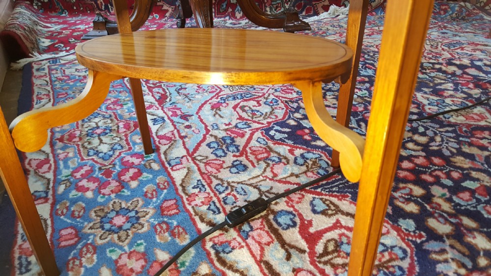 An Edwardian oval satinwood occasional table featuring slender square tapered legs, crossbanded inlay along the top edge, and a small oval lower undertier. View IV