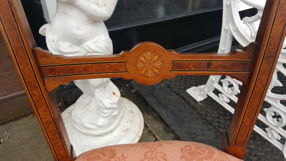 A set of four Victorian walnut salon chairs featuring carved rectangular open backs, turned front legs, and seats upholstered in dusty pink damask with braid trim. View IV