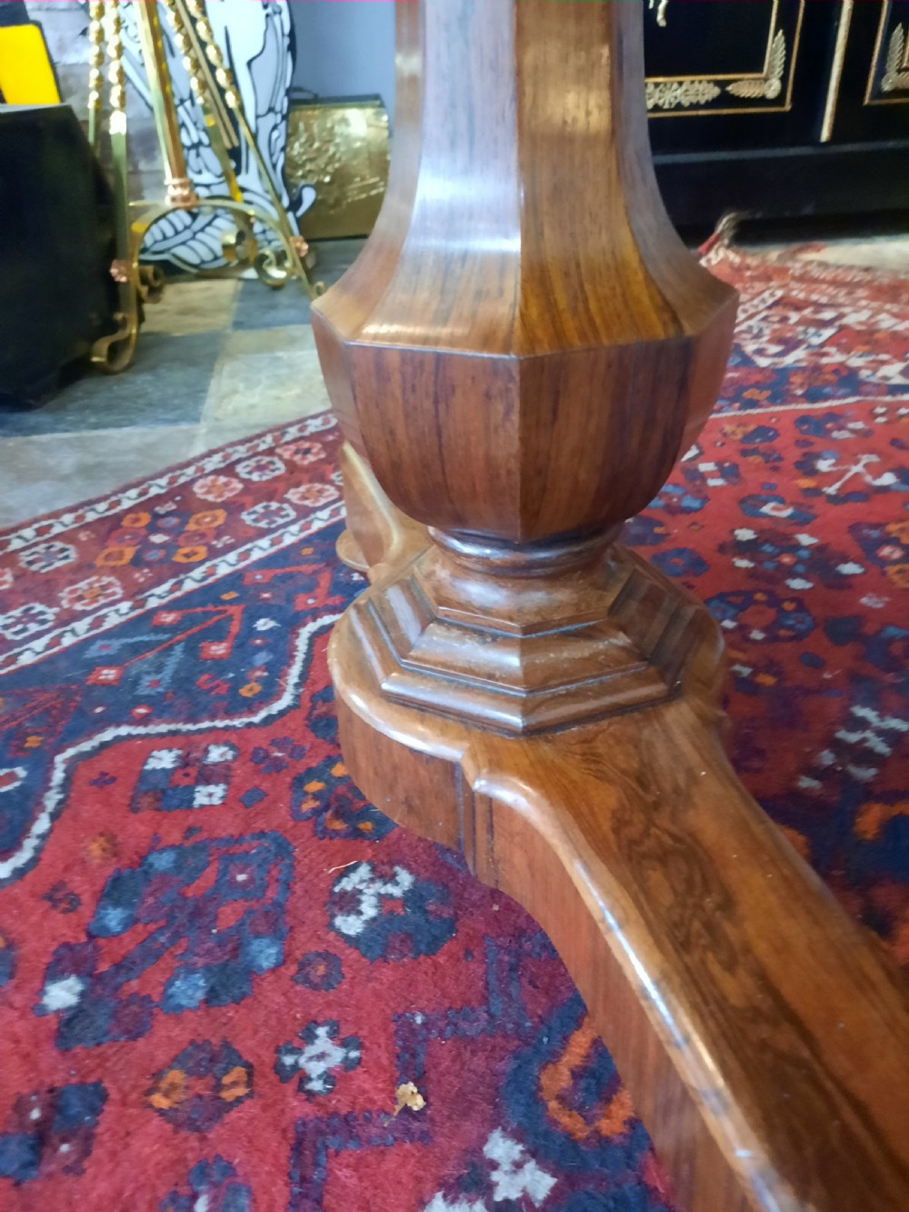 A Late Regency rosewood library table featuring a polished rectangular top with rounded corners, supported by dual faceted end supports resting on stepped plinth bases. View IV