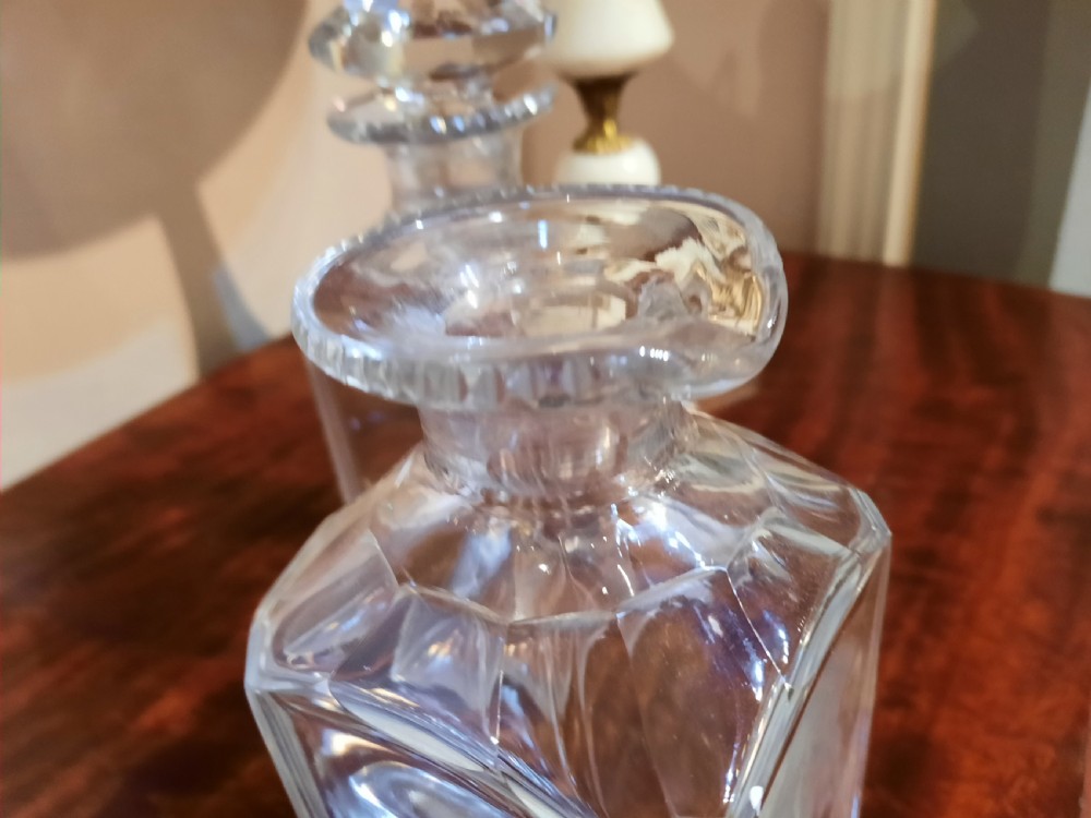 A set of three clear cut glass decanters from the William IV period featuring square bodies and faceted glass stoppers. View III