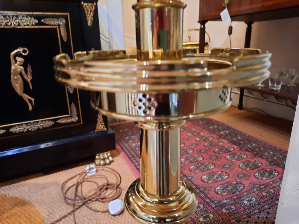A pair of tall turned brass candlesticks fitted with dome-shaped beige fabric shades featuring scalloped fringe detail. View IV