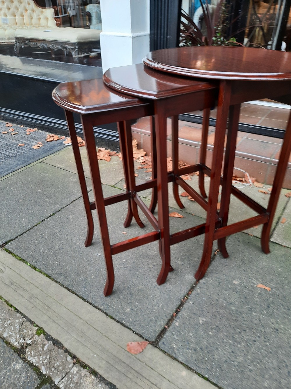 A graduated trio of early twentieth-century mahogany side tables with oval tops, slender legs, and perimeter stretchers. View III