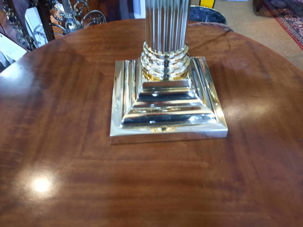 A nineteenth-century brass table lamp featuring a fluted column support, square stepped base, and a decorated fabric shade with hanging fringe. View II