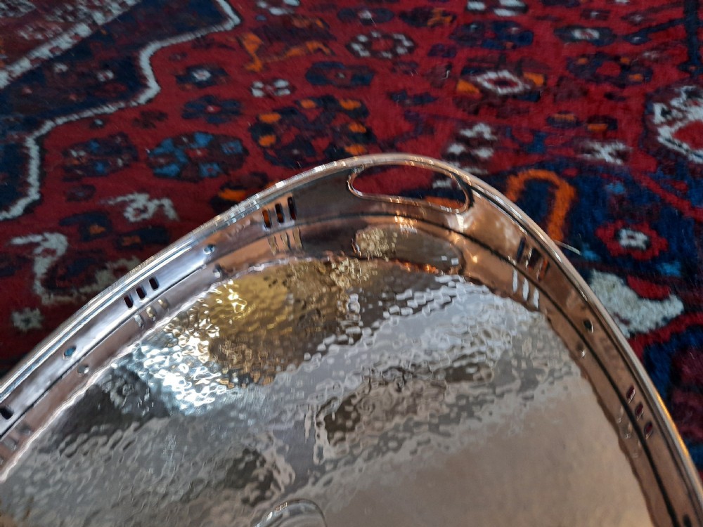 An oval Arts and Crafts hand-hammered copper tray with twin integrated handles and a central motif. View IV