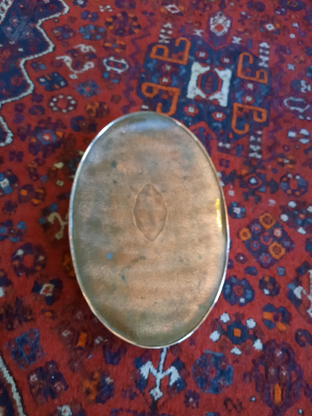 An oval Arts and Crafts hand-hammered copper tray with twin integrated handles and a central motif. View V