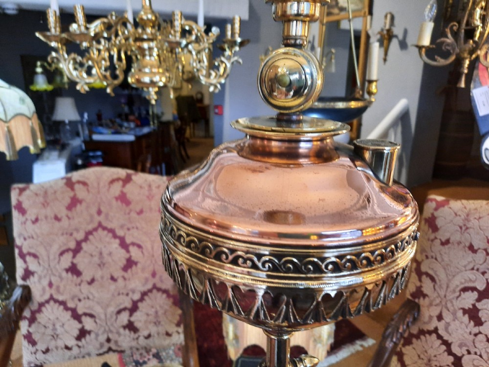 A late Victorian telescopic brass standard lamp featuring tripod scroll feet and a domed floral fabric shade with fringe trim. View II