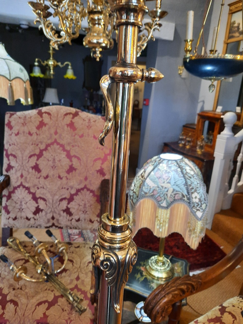 A late Victorian telescopic brass standard lamp featuring tripod scroll feet and a domed floral fabric shade with fringe trim. View III