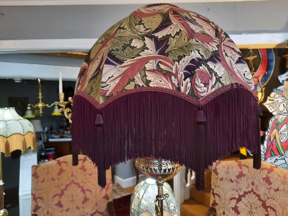 A late Victorian telescopic brass standard lamp featuring tripod scroll feet and a domed floral fabric shade with fringe trim. View VIII