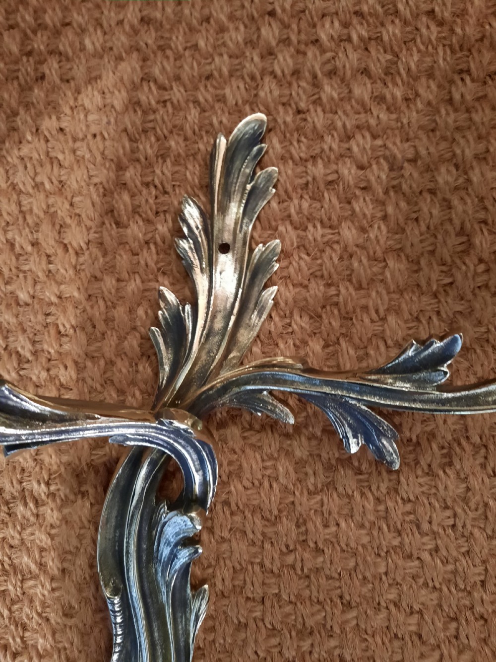 A cast brass twin-arm wall light in the Rococo Revival style featuring scrolling acanthus foliage and white faux candle sockets. View III