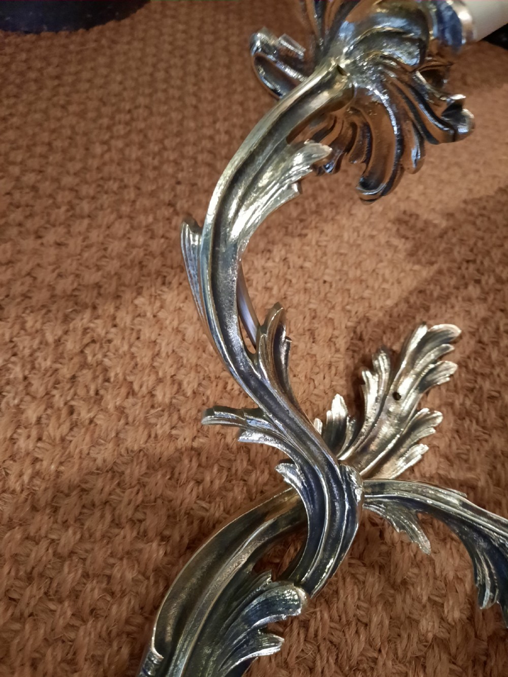 A cast brass twin-arm wall light in the Rococo Revival style featuring scrolling acanthus foliage and white faux candle sockets. View IV