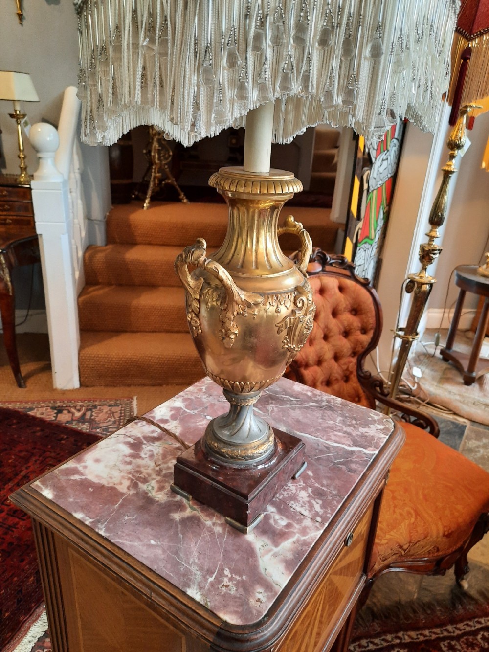 A 19th-century gilt bronze classical urn mounted as a table lamp on a square marble base with a fringed fabric shade. View III
